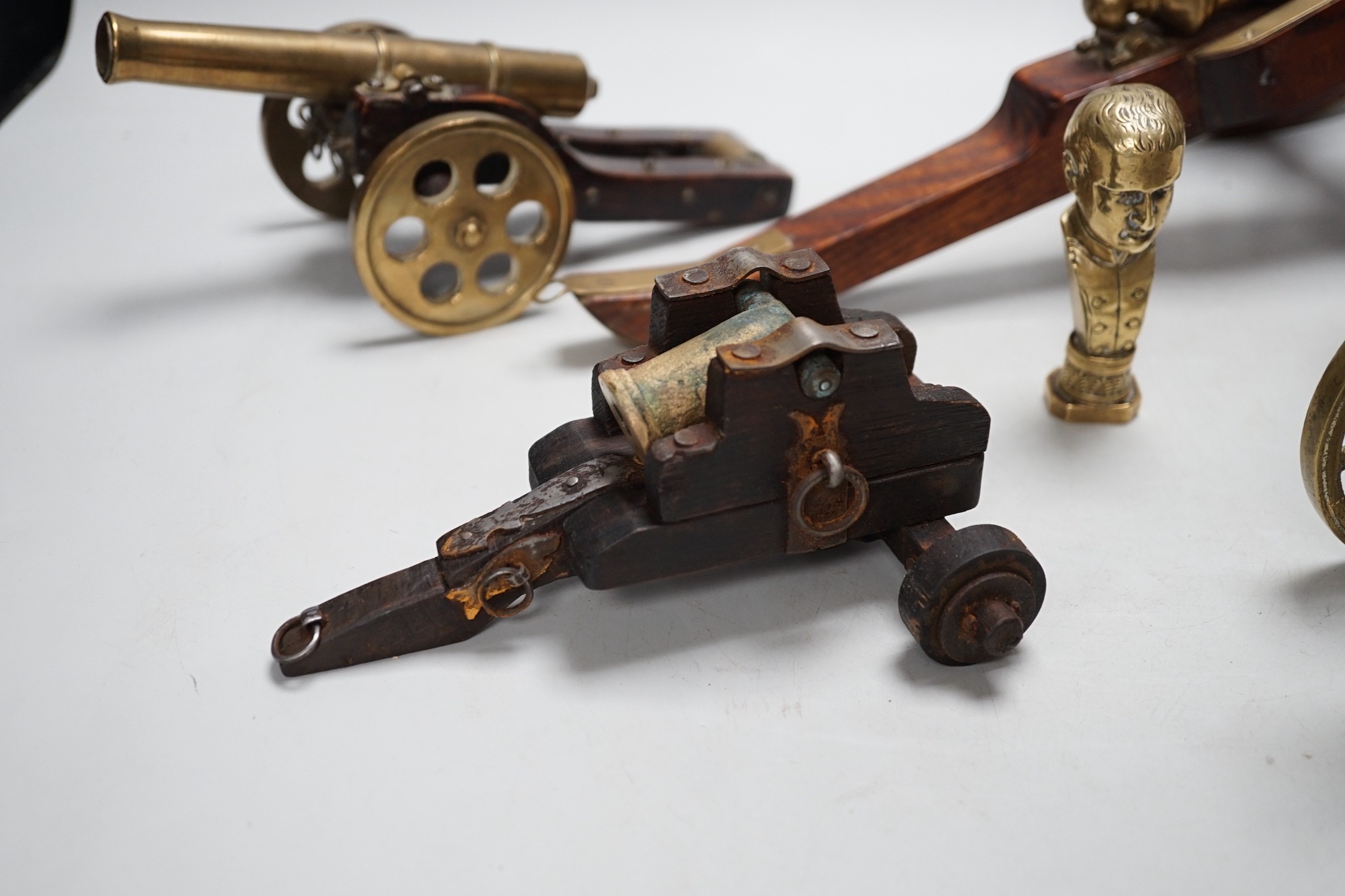 A bronze 'Napoleon bust' desk seal, 8.5cm tall, together with four models of cannons. Largest 39cm wide